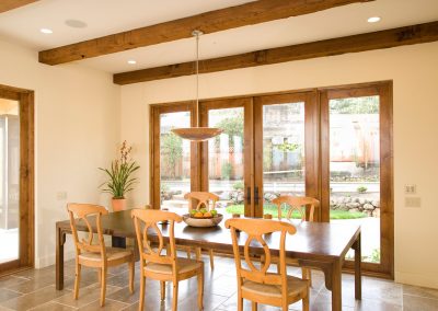 Bay View House dining area with wood beams on ceiling